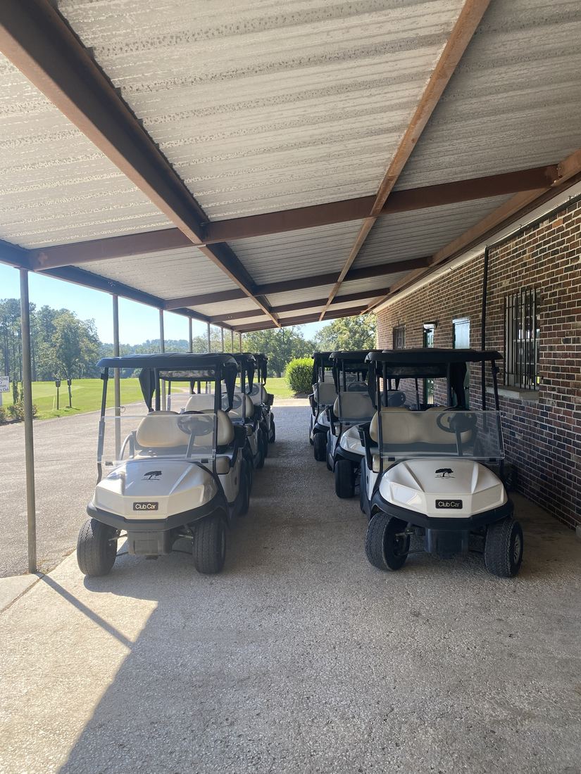 Club cars lined up under the cart barn