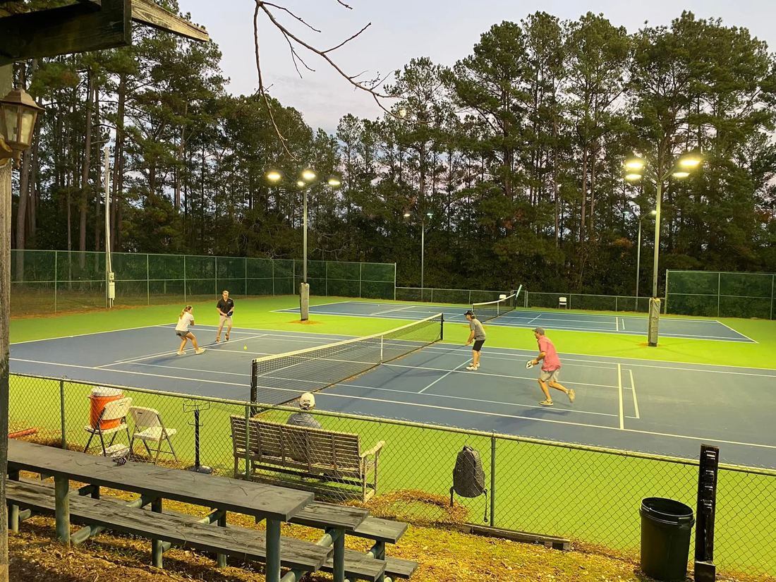Pickleball doubles on the lighted courts at dusk